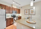Thumbnail 4 of 48 - a kitchen with stainless steel appliances and granite counter tops