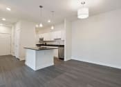 Thumbnail 19 of 36 - an empty living room and kitchen with a counter top