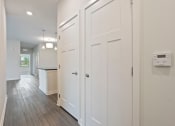 Thumbnail 20 of 36 - a white hallway with white closets and a kitchen