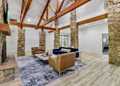 Thumbnail 66 of 71 - A living room with a stone fireplace and wooden beams.