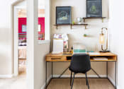 Thumbnail 24 of 39 - a home office with a wooden desk and a black chair