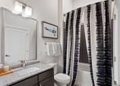 Thumbnail 78 of 95 - a bathroom with a shower toilet and sink and a mirror