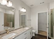 Thumbnail 90 of 95 - a bathroom with two sinks and a shower and a toilet