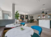 Thumbnail 10 of 39 - a living room with blue chairs and a white table