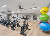 Thumbnail 12 of 39 - a fitness room filled with exercise bikes and helmets