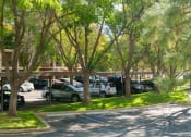Thumbnail 23 of 25 - a parking lot filled with cars and trees