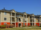 Thumbnail 21 of 25 - Ardenne Apartment Building with beigh and blue paint, green grass, and bright blue skies