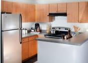 Thumbnail 17 of 25 - Ardenne Apartments kitchen with stainless appliances and light brown cabinets