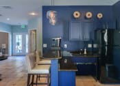 Thumbnail 3 of 25 - a kitchen with blue cabinets and a black counter top