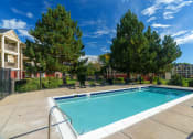 Thumbnail 8 of 25 - a swimming pool with trees and a building in the background
