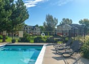 Thumbnail 7 of 25 - a swimming pool with lounge chairs next to a fence