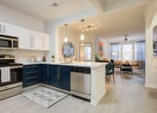 Thumbnail 21 of 39 - a kitchen with blue and white cabinets and a white counter top