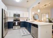 Thumbnail 22 of 39 - a kitchen with blue and white cabinets and stainless steel appliances