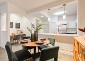 Thumbnail 23 of 39 - a dining room with a table and chairs and a kitchen