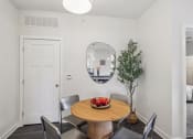 Thumbnail 8 of 36 - a dining room with a table and chairs and a mirror