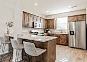 Thumbnail 5 of 11 - A kitchen with a granite countertop and a refrigerator.