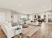 Thumbnail 1 of 11 - A spacious living room with white furniture and a wooden floor.