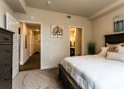 Thumbnail 6 of 30 - A bedroom with a large bed and a painting on the wall.