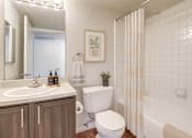 Thumbnail 7 of 23 - A bathroom with a white toilet, sink, and shower.