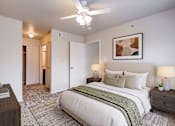 Thumbnail 5 of 23 - A bedroom with a large bed and a ceiling fan.