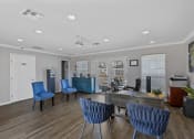 Thumbnail 10 of 16 - a lounge area with blue chairs and a coffee table