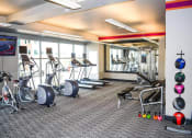 Thumbnail 21 of 33 - a gym with cardio equipment and weights in a building