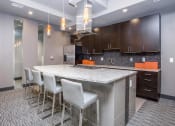 Thumbnail 14 of 33 - a large kitchen with a counter and chairs