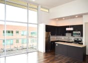 Thumbnail 9 of 33 - an empty kitchen with black cabinets and a large window
