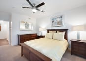 Thumbnail 9 of 36 - a bedroom with a bed and two dressers and a ceiling fan