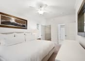Thumbnail 5 of 36 - a white bedroom with a large bed and a ceiling fan