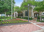 Thumbnail 34 of 36 - a courtyard with flowers and trees in front of a building
