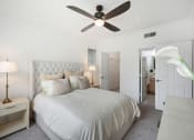 Thumbnail 8 of 36 - a white bedroom with a bed and a ceiling fan