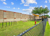 Thumbnail 42 of 48 - a brick wall with a chain link fence and a red fire hydrant