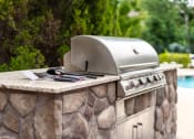 Thumbnail 21 of 48 - an outdoor kitchen with a grill and a barbecue