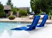 Thumbnail 16 of 48 - a pair of blue chairs sitting next to a swimming pool