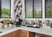 Thumbnail 43 of 71 - A coffee bar with a coffee machine and cups on a counter.