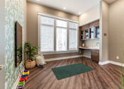 Thumbnail 20 of 22 - A room with a green rug and wooden floors.