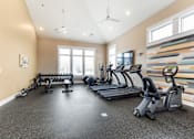 Thumbnail 19 of 22 - A spacious home gym with a variety of exercise equipment.