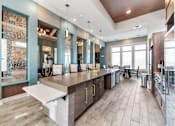Thumbnail 14 of 22 - One Bedroom Luxury Apartments in Shawnee, KS - Bonavia Luxury Apartments - Clubhouse Kitchen with Stainless Steel Appliances, Expansive Island with Seating, and Pendant Lights.