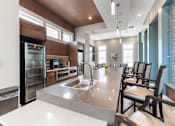 Thumbnail 16 of 22 - A modern kitchen with a large island and chairs.