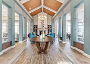 Thumbnail 13 of 22 - A large wooden table is in the middle of a room with blue walls and wooden floors.