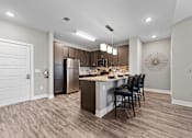 Thumbnail 5 of 22 - A modern kitchen with a wooden floor and a large island.