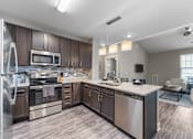 Thumbnail 4 of 22 - A modern kitchen with stainless steel appliances and wooden cabinets.