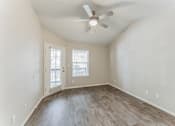 Thumbnail 15 of 22 - A room with a ceiling fan and wooden flooring.