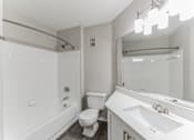 Thumbnail 17 of 22 - A white bathroom with a toilet, sink, and bathtub.