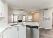 Thumbnail 8 of 22 - A kitchen with white cabinets and a stainless steel dishwasher.