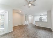 Thumbnail 11 of 22 - A spacious room with a ceiling fan and wooden flooring.