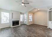 Thumbnail 13 of 22 - A spacious living room with a fireplace and hardwood floors.
