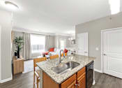 Thumbnail 11 of 71 - A kitchen with a granite countertop and a sink.