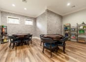 Thumbnail 32 of 48 - a game room with a table and chairs and a brick wall